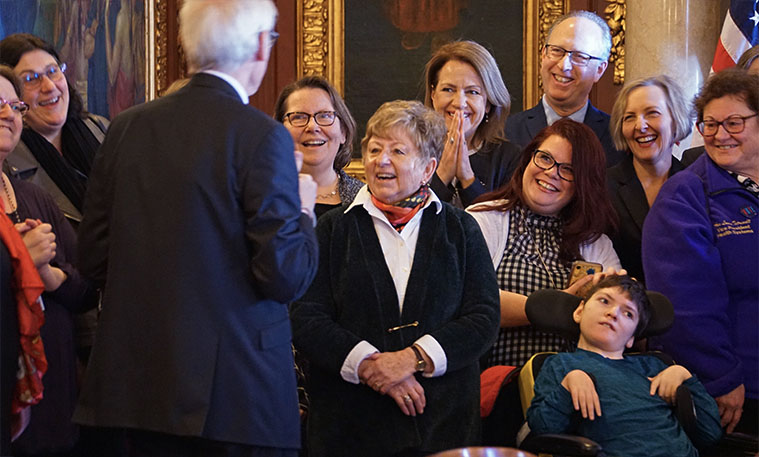 Group of smiling men and women advocating for disability rights