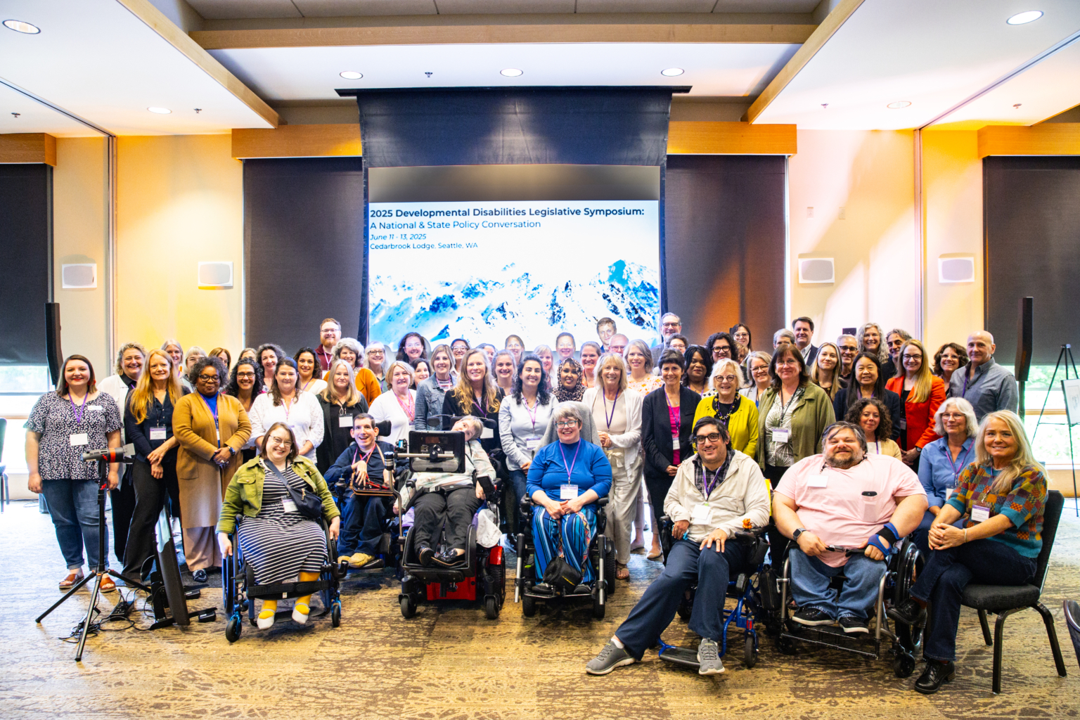 A group of approximately 50 adults gathered for a group photo and smiling at the camera